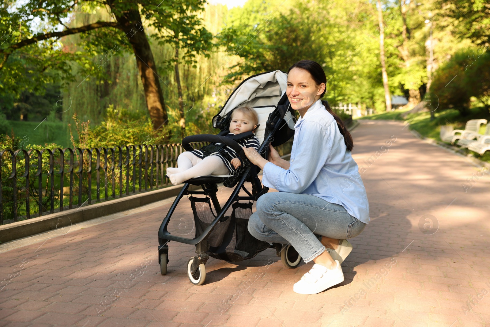 Mother with her cute baby in stroller at park Photo of Mother with her cute baby in stroller at park
