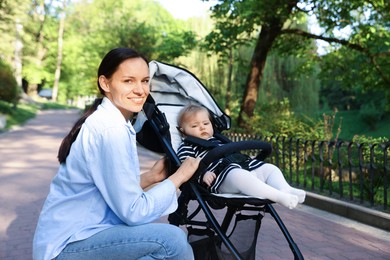 Photo of Mother with her cute baby in stroller at park