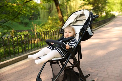 Photo of Cute little baby in stroller at park. Space for text