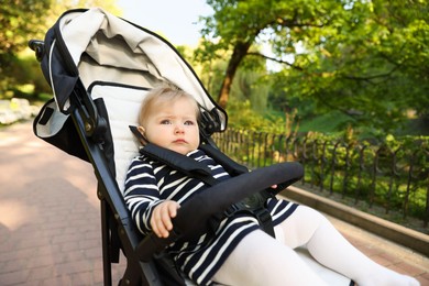 Photo of Cute little baby in stroller at park. Space for text
