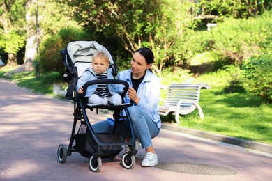 Photo of Mother with her cute baby in stroller at park