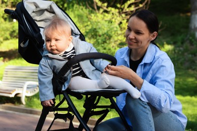 Photo of Mother with her cute baby in stroller at park