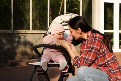 Photo of Mother with her cute baby in stroller at park