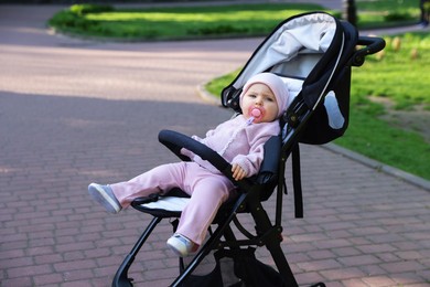 Photo of Cute little baby in stroller at park. Space for text