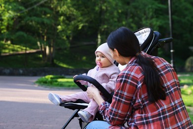 Photo of Mother with her cute baby in stroller at park