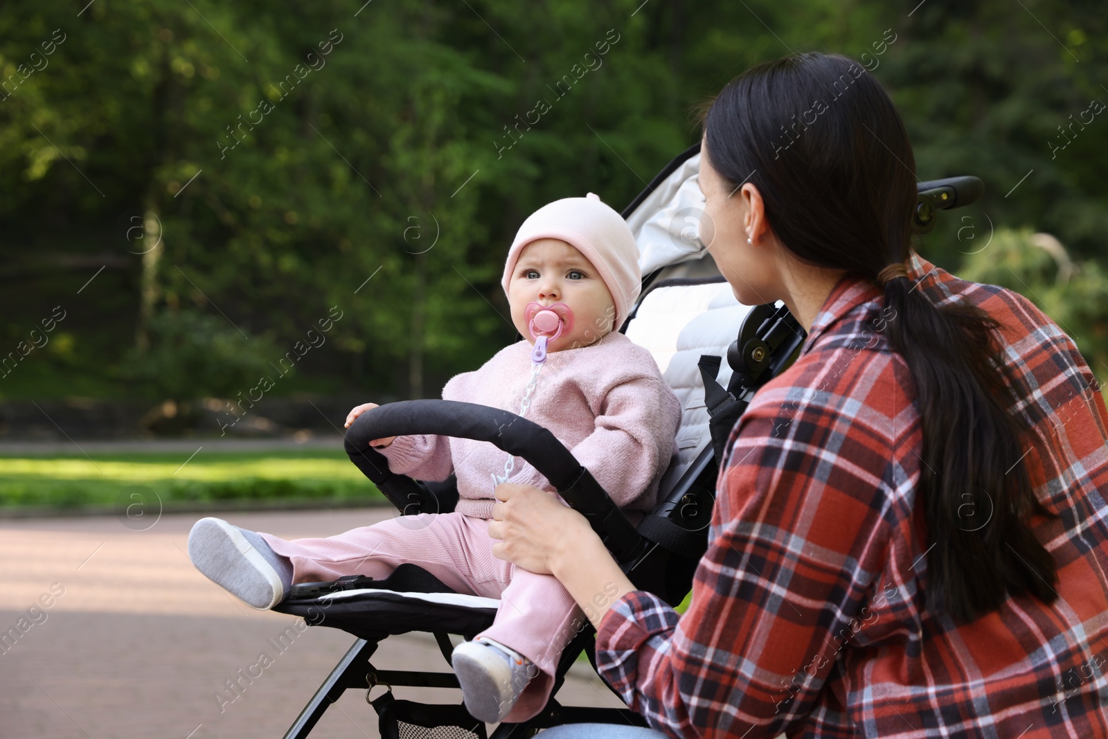Mother with her cute baby in stroller at park Photo of Mother with her cute baby in stroller at park