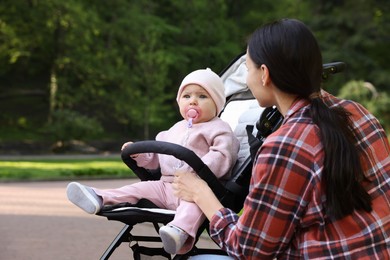 Photo of Mother with her cute baby in stroller at park