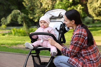 Photo of Mother with her cute baby in stroller at park