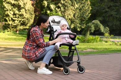 Photo of Mother with her cute baby in stroller at park
