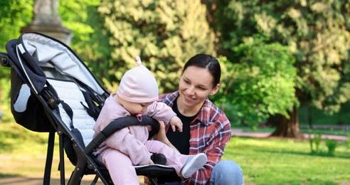 Photo of Mother with her cute baby in stroller at park
