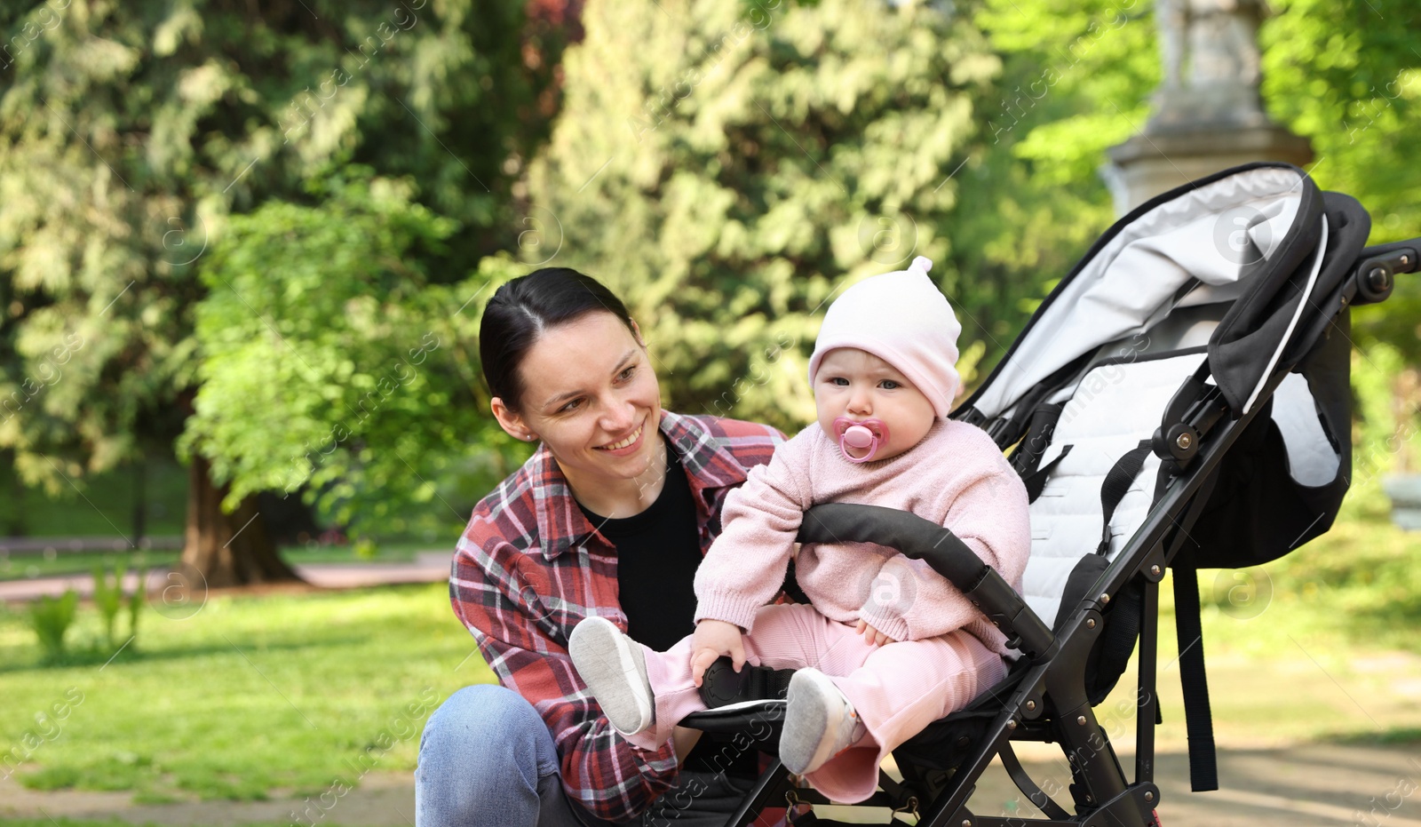 Mother with her cute baby in stroller at park Photo of Mother with her cute baby in stroller at park