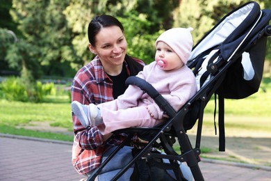 Photo of Mother with her cute baby in stroller at park