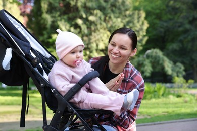 Photo of Mother with her cute baby in stroller at park