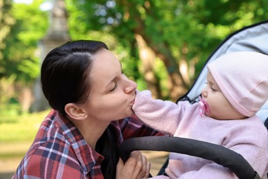 Photo of Mother with her cute baby in stroller at park