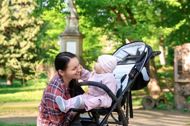 Photo of Mother with her cute baby in stroller at park