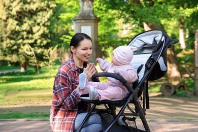 Photo of Mother with her cute baby in stroller at park