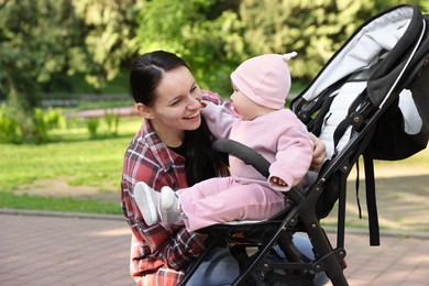 Photo of Mother with her cute baby in stroller at park