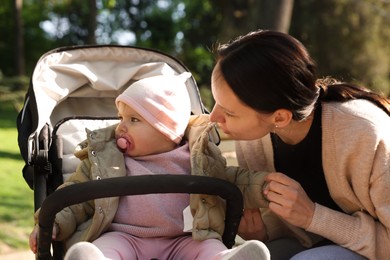 Photo of Mother with her cute baby in stroller at park