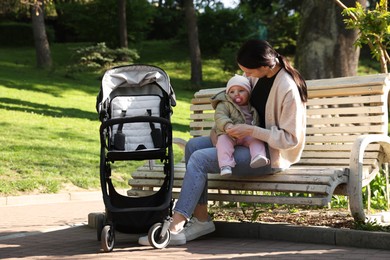 Photo of Mother with her cute baby on bench in park