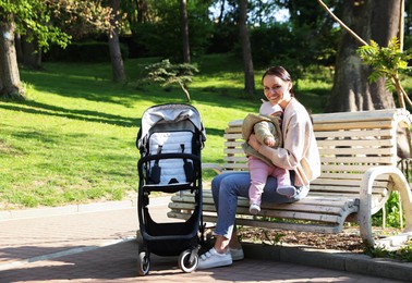 Photo of Mother with her cute baby on bench in park