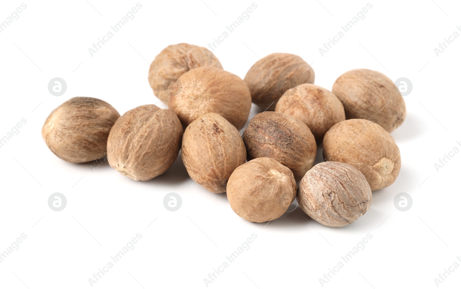 Pile of fresh nutmegs isolated on white Photo of Pile of fresh nutmegs isolated on white