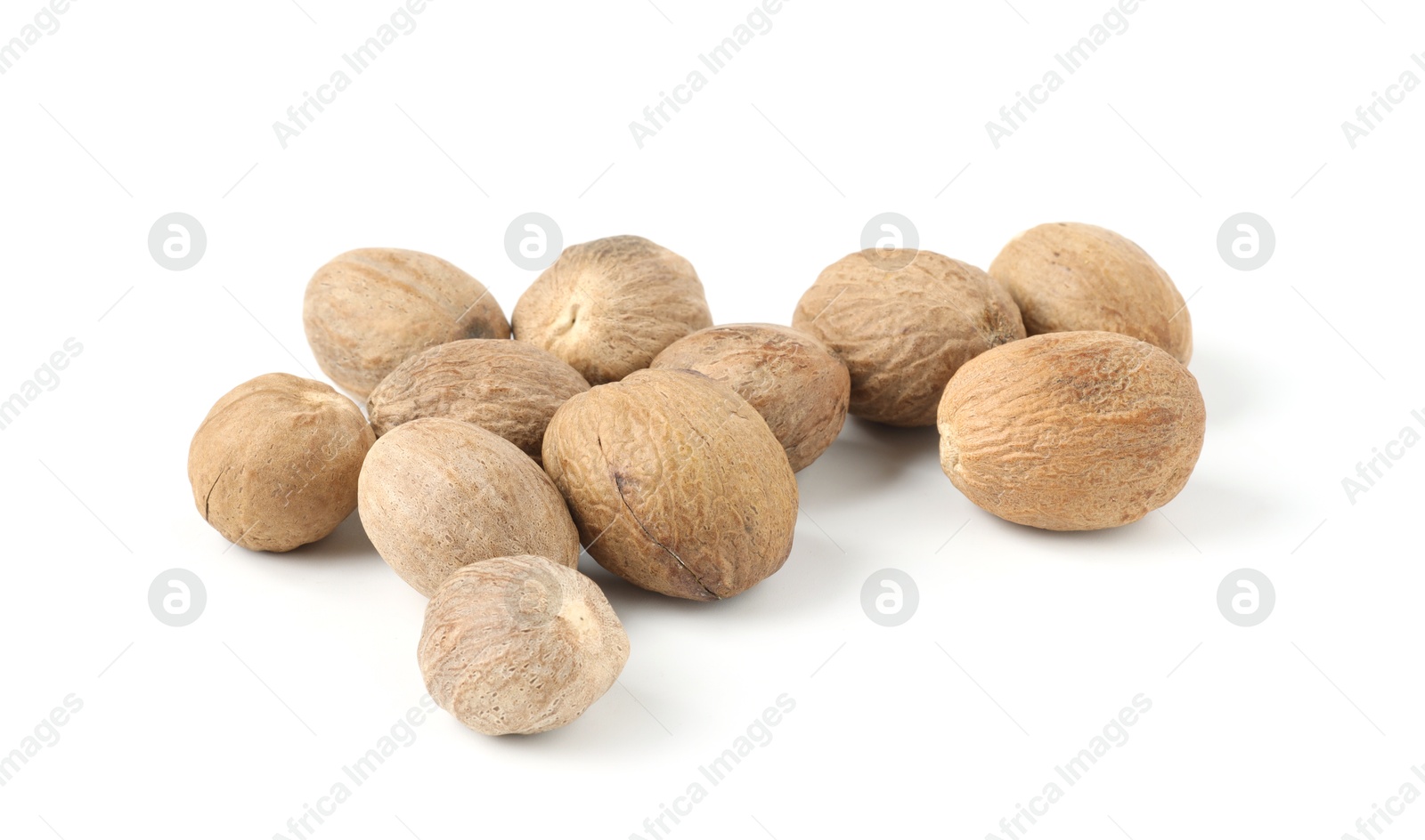 Pile of fresh nutmegs isolated on white Photo of Pile of fresh nutmegs isolated on white