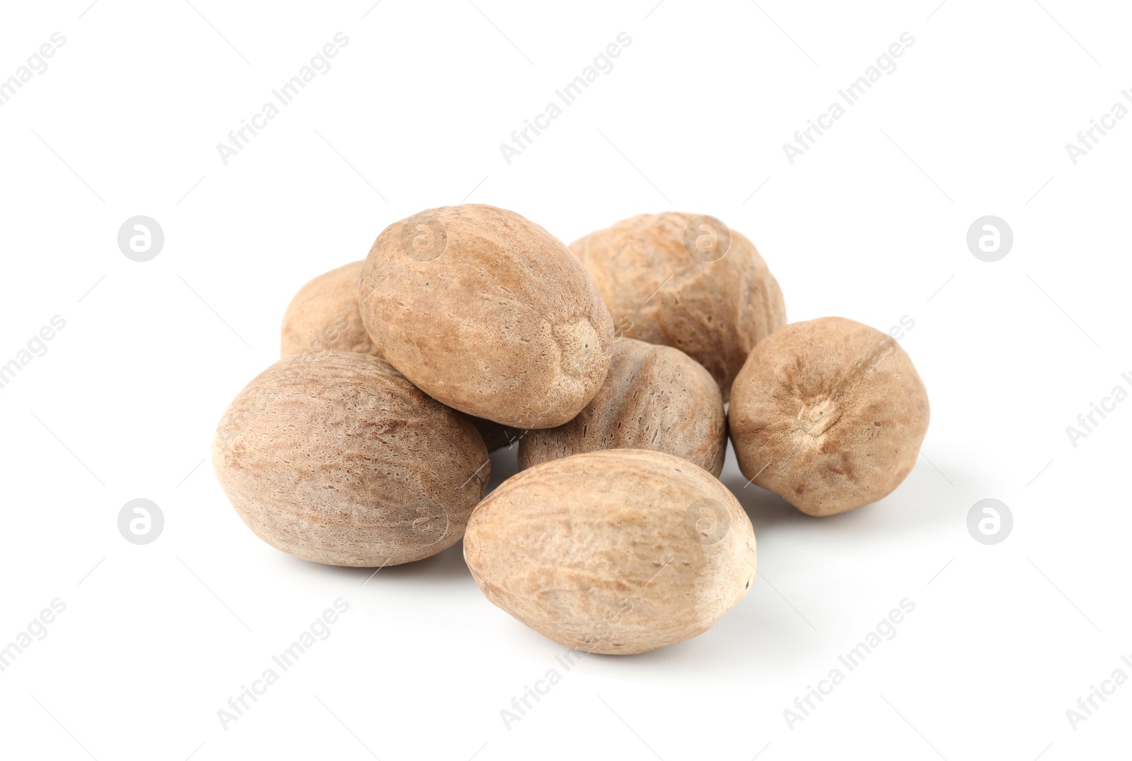 Pile of fresh nutmegs isolated on white Photo of Pile of fresh nutmegs isolated on white