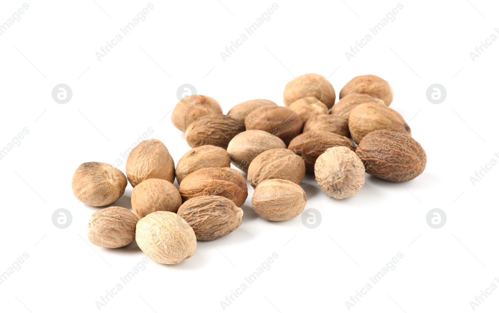 Pile of fresh nutmegs isolated on white Photo of Pile of fresh nutmegs isolated on white