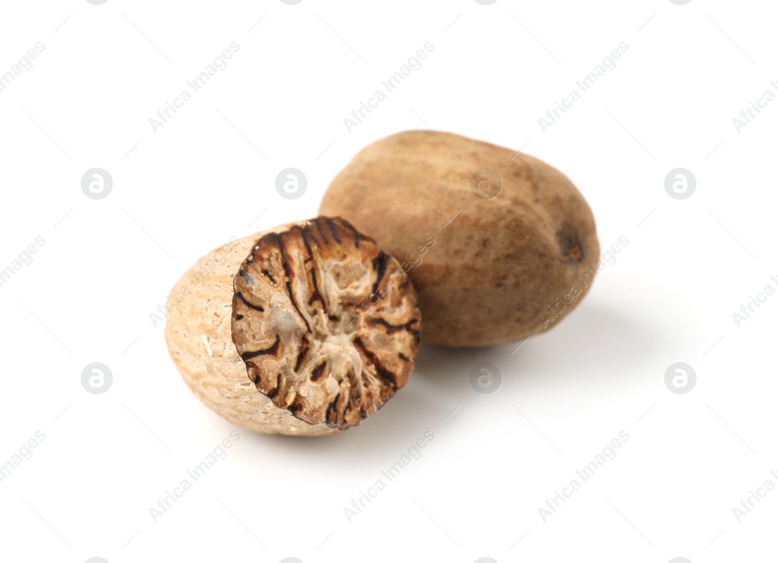 Photo of Whole and cut nutmegs isolated on white