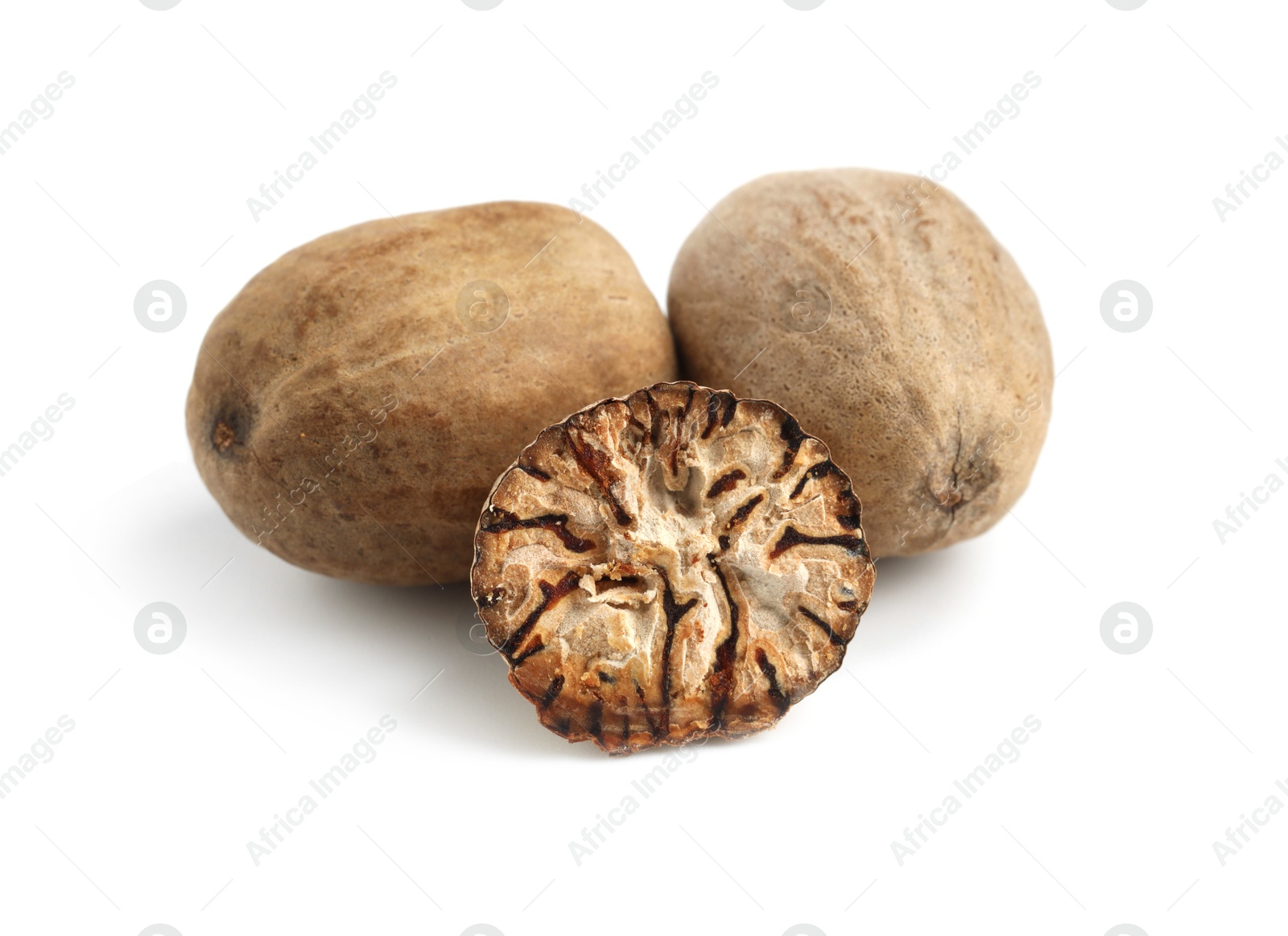 Whole and cut nutmegs isolated on white Photo of Whole and cut nutmegs isolated on white