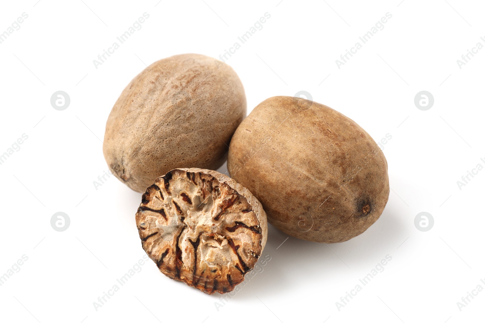 Whole and cut nutmegs isolated on white Photo of Whole and cut nutmegs isolated on white