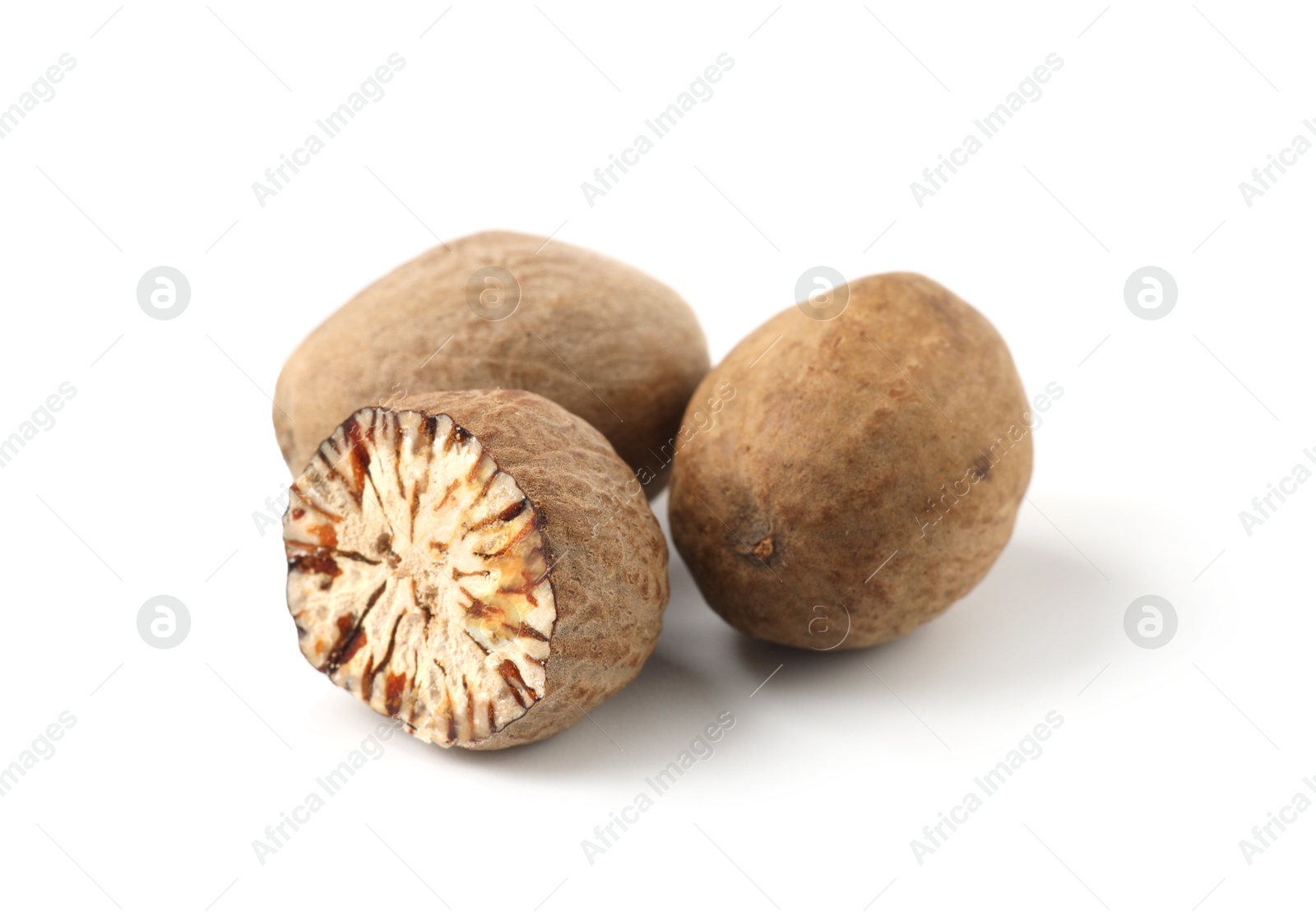 Whole and cut nutmegs isolated on white Photo of Whole and cut nutmegs isolated on white