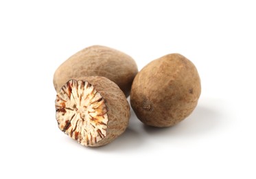 Photo of Whole and cut nutmegs isolated on white