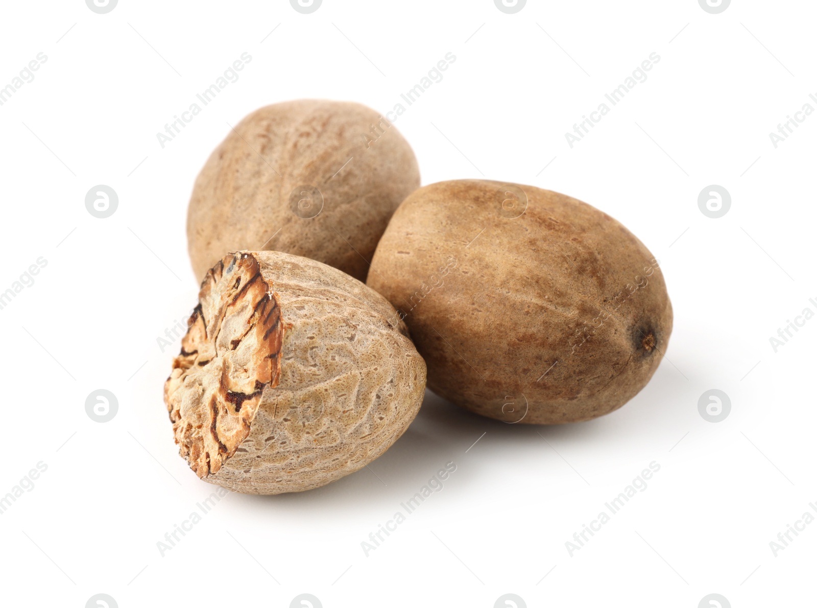 Photo of Whole and cut nutmegs isolated on white