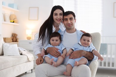 Photo of Happy family. Parents with their twin babies at home