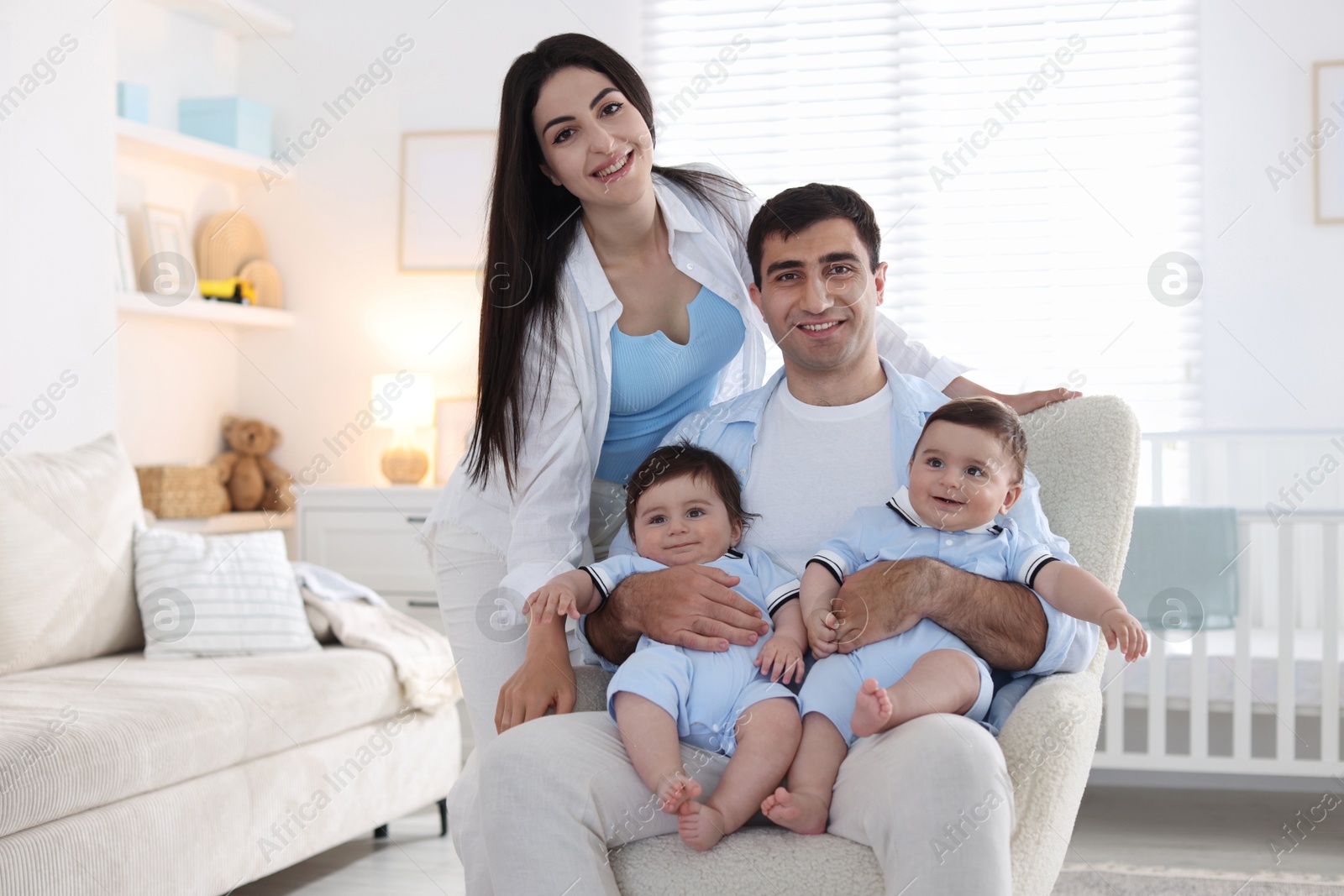 Happy family. Parents with their twin babies at home Photo of Happy family. Parents with their twin babies at home