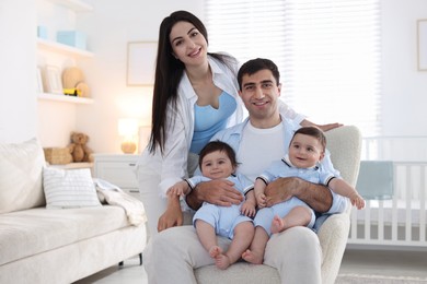 Photo of Happy family. Parents with their twin babies at home