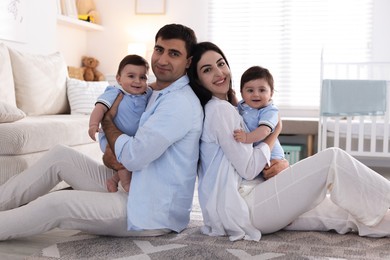 Photo of Happy family. Parents with their twin babies at home