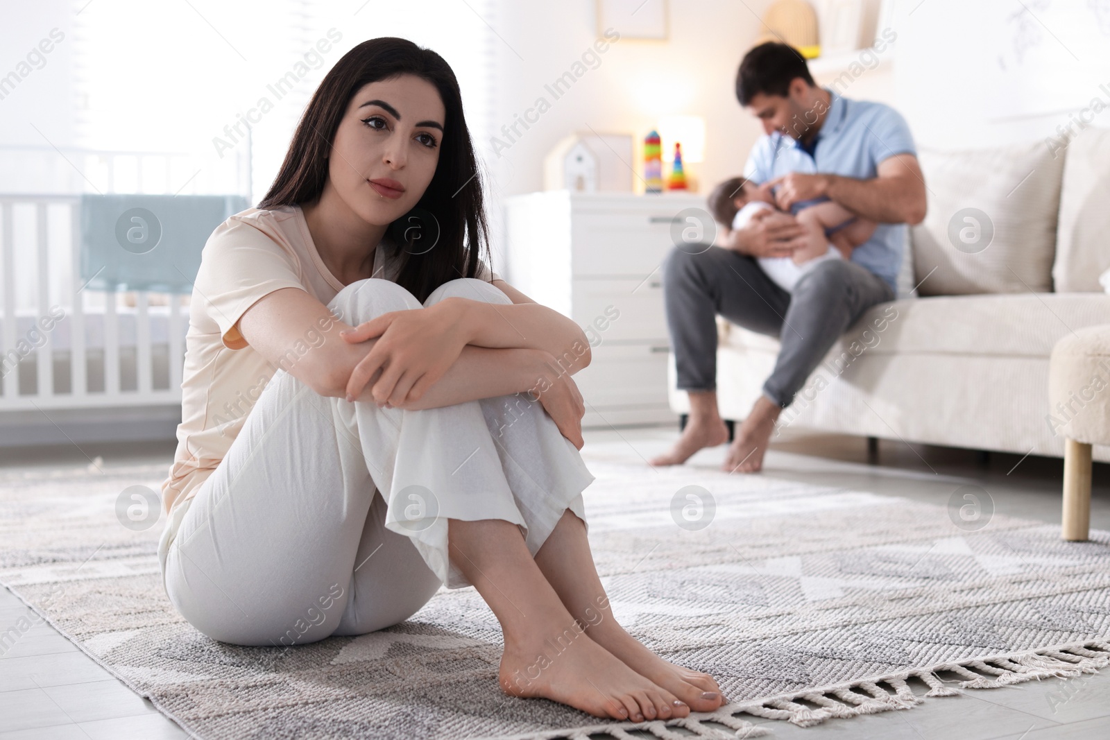 Woman suffering from postpartum depression and her husband with baby at home, selective focus Photo of Woman suffering from postpartum depression and her husband with baby at home, selective focus