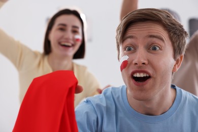 Photo of Emotional sports fans watching game together indoors, selective focus
