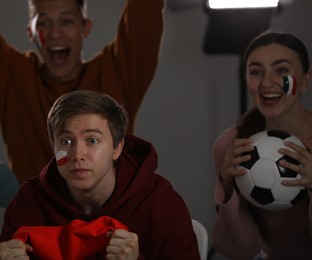 Photo of Emotional sports fans watching game together indoors, selective focus