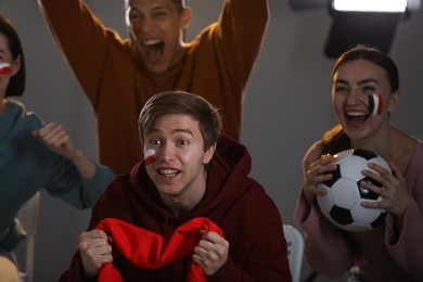 Photo of Emotional sports fans watching game together indoors, selective focus