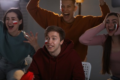 Photo of Emotional sports fans watching game together indoors, selective focus