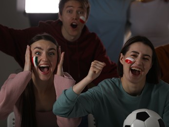 Photo of Emotional sports fans watching game together indoors, selective focus