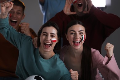 Photo of Emotional sports fans watching game together indoors, selective focus
