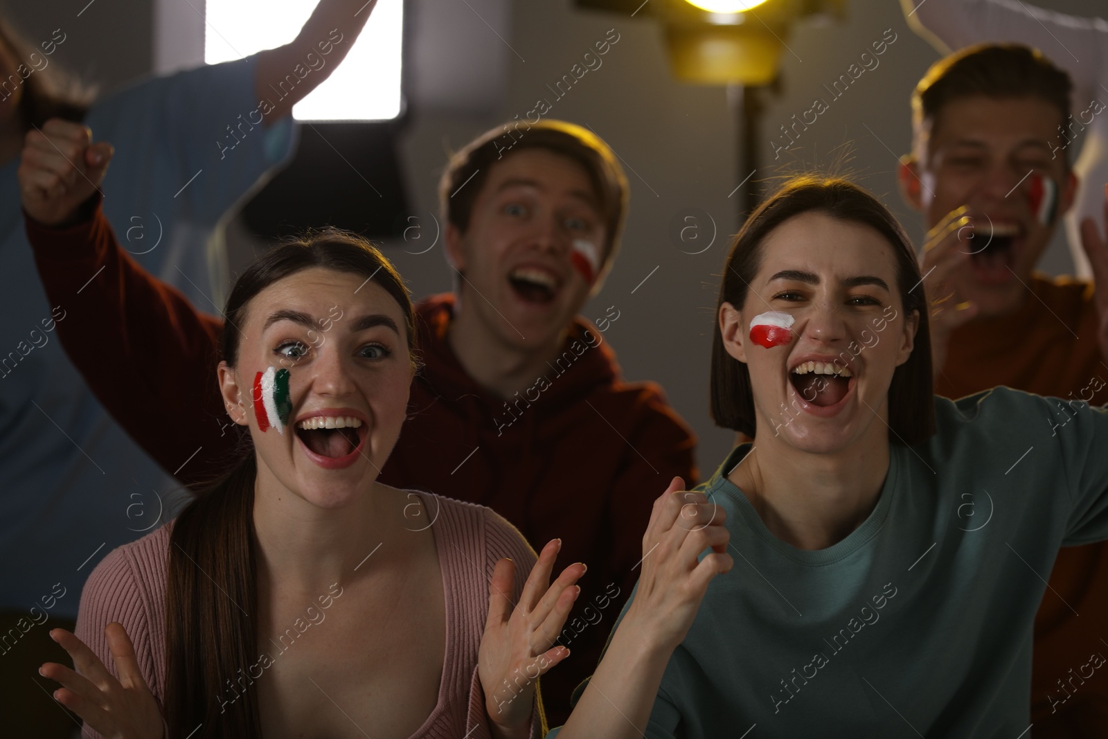 Emotional sports fans watching game together indoors, selective focus Photo of Emotional sports fans watching game together indoors, selective focus