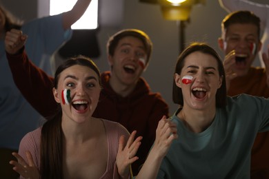 Photo of Emotional sports fans watching game together indoors, selective focus