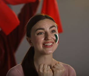 Photo of Emotional sports fan with drawing of Italian flag watching game indoors