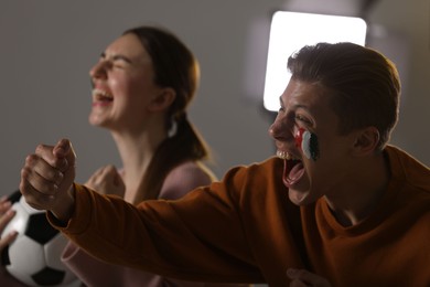 Photo of Emotional football fans watching game together indoors