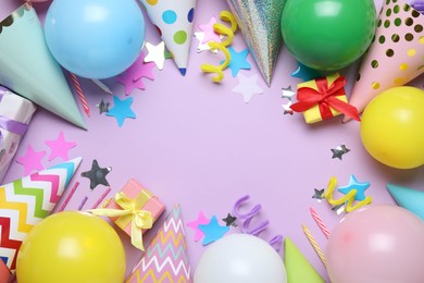 Photo of Beautiful party hats and other festive decor on lilac background, flat lay. Space for text